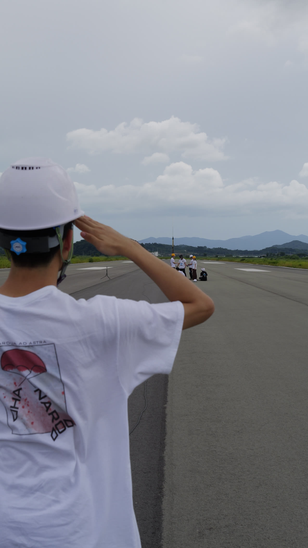 A team member in a HANARO shirt and hard hat on the apron, watching the pad down the runway